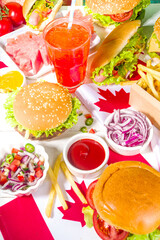 Set of various Canada Day bbq food. Picnic party table with maple leaf shaped watermelon, flags,...