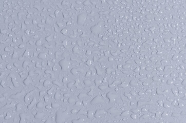 Large and small drops of water on the blue background of the mine space. Texture of water drops top view.