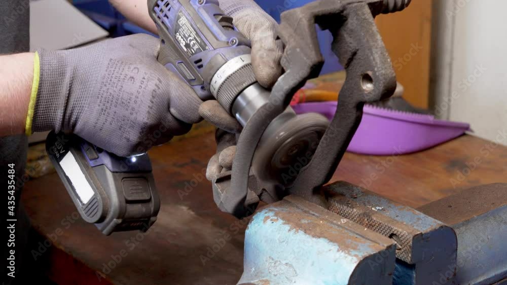 Poster man removes rust of brake caliper mount before assembling. close up