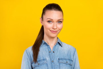 Photo of attractive young nice lady ponytail hair good mood wear denim shirt isolated on shine yellow color background