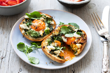 Eggs baked inside brioche bun with watercress and feta