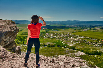 girl in sportswear at the top of the mountain
