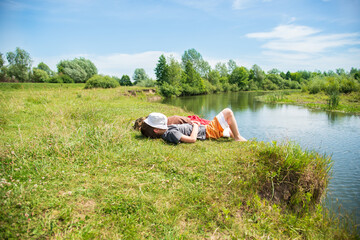 Children rest on the banks of the river in the summer