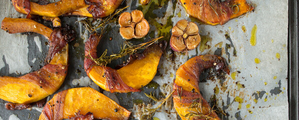 baked pumpkin with bacon and rosemary on a baking sheet