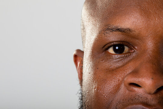 Close up of eye of african american businessman against grey background