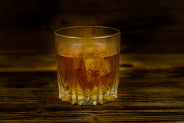 Glass of whiskey on the dark wooden background