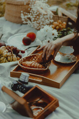 Woman's hand takes croissant. Picnic still life