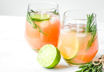 fitness cocktail in glass with lime and rosemary on white table background mock-up