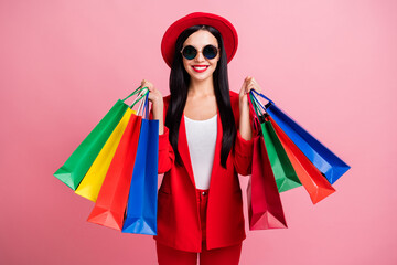 Photo portrait of glamorous woman with shopping bags isolated on pastel pink colored background