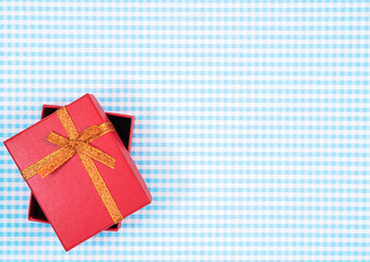 gift box with red isolated on Plaid background. Holiday decoration for Mother's Day or Women's Day.