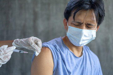 Asian male getting vaccinated during covid-19 pandemic - obrazy, fototapety, plakaty