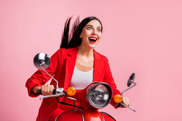 Photo of young crazy smiling cheerful girl look copyspace riding fast speed moped isolated on pink color background