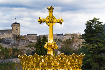 Couronne dor&eacute;e et croix sur basilique de Lourdes face au ch&acirc;teau fort 