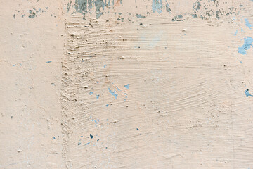 weathered and chipped cream-pink white paint on a wall
