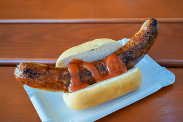 Fried sausage with ketchup on a fresh bun in a cafe in Germany