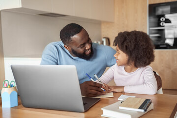 Happy young parent father help child daughter with distance learning from home