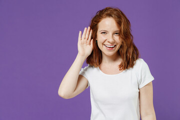 Young smiling curious nosy caucasian woman 20s wear white basic casual t-shirt try to hear you...