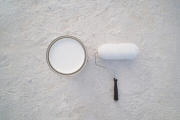 New paint roller and waterproof a tin of paint on cement rooftop..