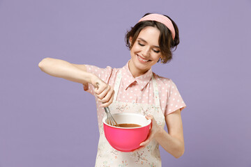 Young smiling happy cheerful housewife housekeeper chef cook baker woman wear pink apron beating...