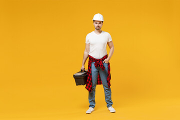 Full length young fun excited employee handyman man 20s in protective helmet hardhat tool case box...