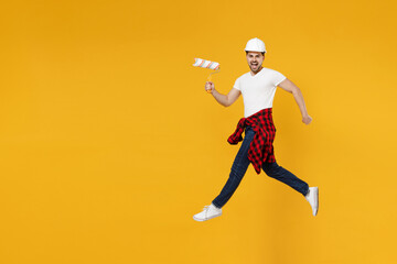 Fototapeta na wymiar Full length young employee handyman man wear t-shirt holding paint roller jump high look camera isolated on yellow background Instruments accessories renovation apartment room. Repair home concept
