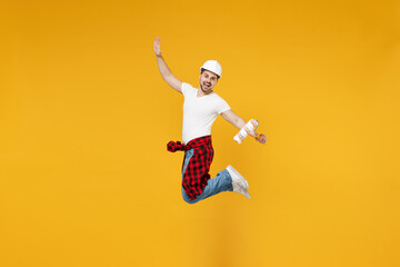 Full length young overjoyed employee handyman man wear t-shirt holding paint roller jump high isolated on yellow background Instruments accessories for renovation apartment room. Repair home concept