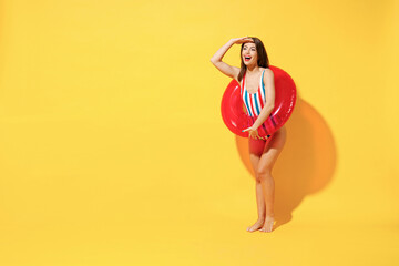Full length happy young sexy woman slim body wear red blue swimsuit posing with inflatable rubber...