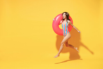 Full length happy young sexy woman slim body wear red blue swimsuit run posing hold inflatable...