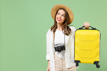 Traveler dreamful tourist woman in casual clothes hat camera hold yellow suitcase valise look aside...