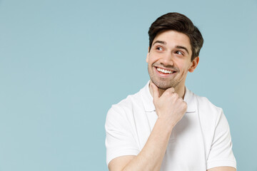 Young pensive dreamful unshaven cheerful caucasian man 20s wearing white casual basic t-shirt prop...