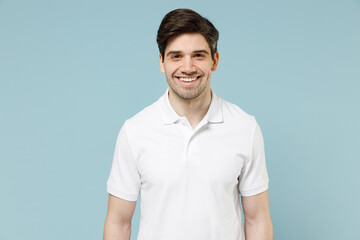 Young fun smiling happy attractive unshaven cheerful caucasian man 20s in white casual basic t-shirt looking camera isolated on pastel blue color background studio portrait. People lifestyle concept