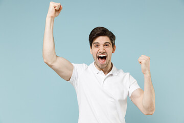 Young overjoyed happy unshaven caucasian man 20s wear white casual basic t-shirt do winner gesture...