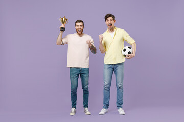 Full length young fun men friends together in casual t-shirt hold in hand champion cup soccer...