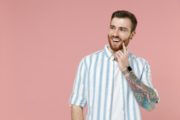 Young dreamful pensive thoughtful caucasian unshaven man 20s wear blue striped shirt white t-shirt...