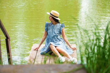 Young beautiful brunette girl in a blue dress