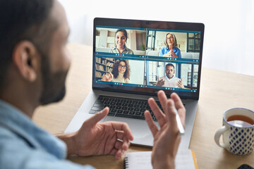 Latin indian businessman having virtual team meeting group call chatting with diverse people in...