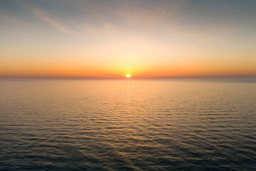 The sun casts golden light out over a body of water at dawn