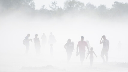 People walking on the beach in the fog. Sunny, hot summer day, but cold water. Pavilosta, Latvia.
