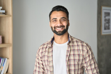 Headshot portrait of attractive confident indian Hispanic man with toothy smile looking at camera...