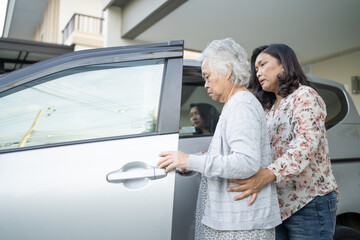 Help and support asian senior or elderly old lady woman patient sitting on wheelchair prepare get to her car : healthy strong medical concept.