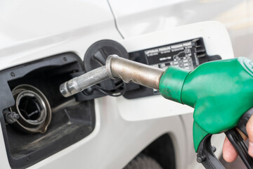 Close up image of green fuel pump near car tank ready for refueling car with gas or diesel.