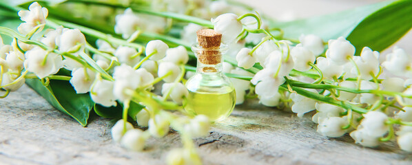 Lily of the valley essential oil in a small bottle. Selective focus.