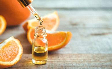 Orange essential oil in a small bottle. Selective focus.