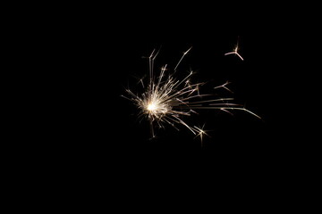 Burning christmas sparkler isolated on black background