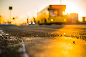 Bright winter sun in a big city, the headlights of approaching bus. View from the level of asphalt