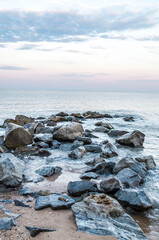 Sea stones boulders sandy shore. Natural landscape.