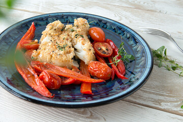 halibut fillet in bread crumbs with vegetables on a plate
