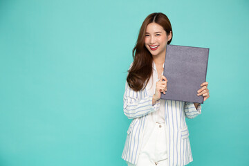 Happy Asian professional businesswoman wearing a suit and holding document files or portfolio on...