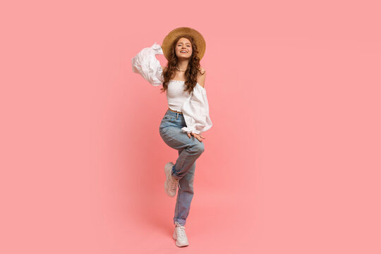  Full lenght image of Ppayful  woman in elegant linen top with balloon sleeves and blue jeans posing on pink background.  Summer fashion trends.