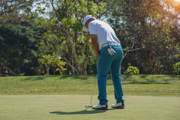 Golfers are putting golf in the evening golf course golf backglound. Golfer hitting golf ball....